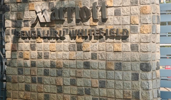 Marriott Bengaluru Whitefield metal lettering mounted on a textured stone wall near Prestige Evergreen