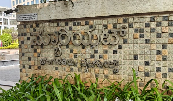 Marriott hotel branding in Kannada script on a stone wall near Prestige Evergreen
