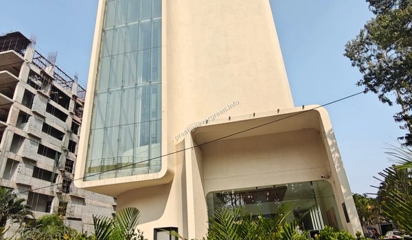 Modern beige tower structure with a vertical glass facade section near Prestige Evergreen