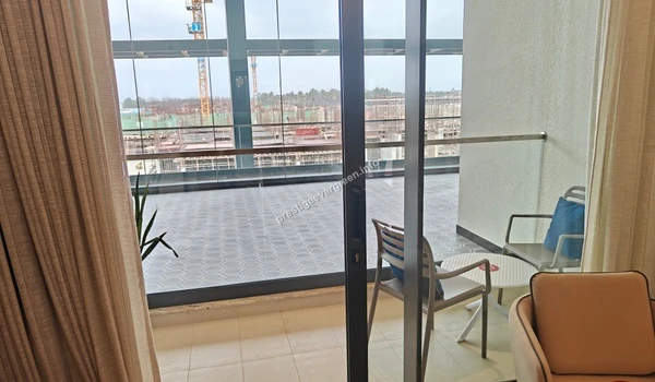 Large private balcony at Prestige Evergreen featuring premium tiling and a glass railing for clear views
