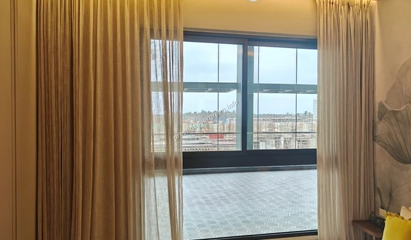 Elegant window dressing with floor-to-ceiling sheer and blackout curtains in the Prestige Evergreen master bedroom