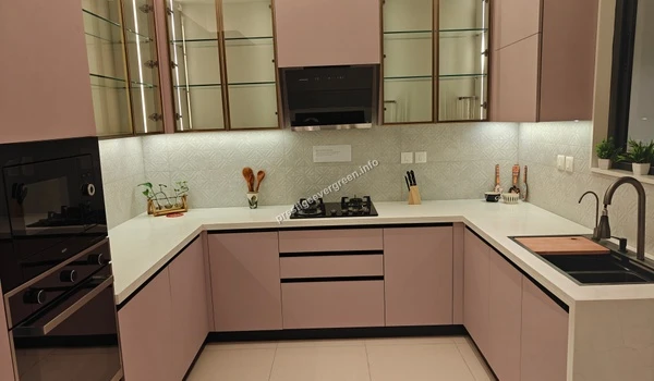 Modern U-shaped kitchen at Prestige Evergreen 1486 sqft model unit featuring pink cabinets and white countertops