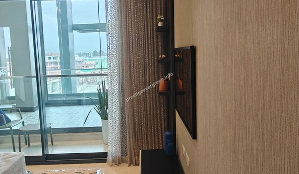 Living room perspective at Prestige Evergreen showing decorative wall finishes and view toward the private balcony