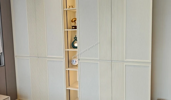Elegant white textured wardrobe with built-in illuminated display shelves in a luxury 3 BHK bedroom at Prestige Evergreen