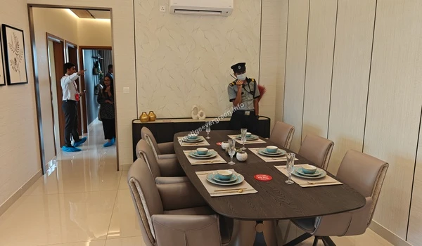 Elegant dining area within a 3 BHK model unit at Prestige Evergreen showcasing a six-seater dining table and premium interior wall treatments