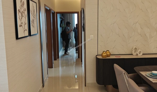 Interior view of a well-lit hallway in a 3 BHK model apartment at Prestige Evergreen leading to the bedrooms with elegant wall art and polished flooring