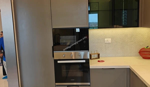 Integrated kitchen appliances in a 3 BHK model apartment at Prestige Evergreen featuring a high-end built-in microwave and oven set within grey cabinetry