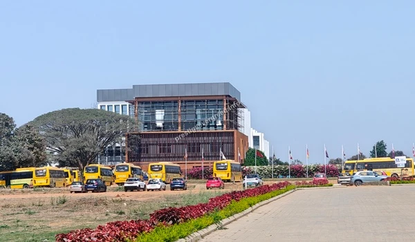 A wide-angle perspective of the Basil Woods International School campus featuring the main academic block and school transport facilities near Prestige Evergreen