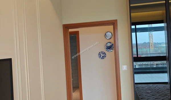 Interior view of a bedroom at Prestige Evergreen showcasing decorative wall plates, premium wall molding, and access to the balcony area