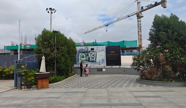View of the ongoing construction site at Prestige Evergreen with tower structures and heavy-duty cranes in the background