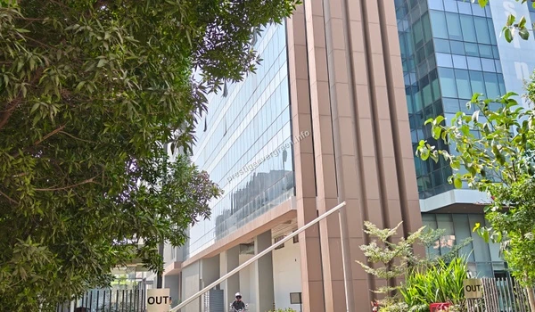 Side perspective of a corporate tech plaza featuring glass facades and green landscaping near the Prestige Evergreen site