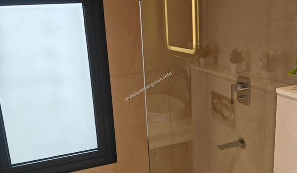 Modern bathroom interior at Prestige Evergreen showcasing a premium tabletop wash basin, stylish chrome fixtures, and a glow-effect rectangular mirror