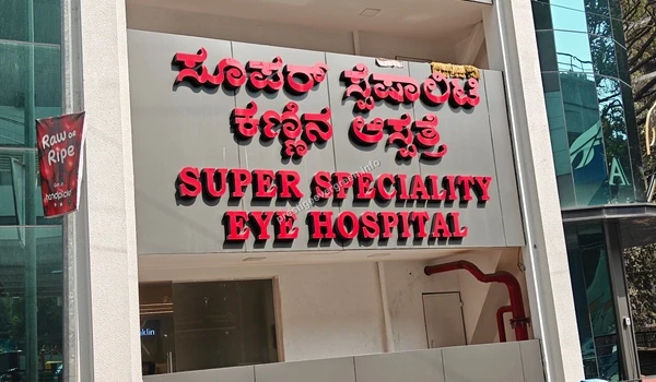 Prominent red 3D wall mounting signage for the Super Speciality Eye Hospital displayed on a grey facade near Prestige Evergreen