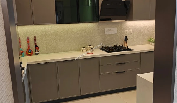 Gourmet modular kitchen at Prestige Evergreen featuring contemporary grey cabinetry, a high-end hob and chimney, and under-cabinet LED task lighting