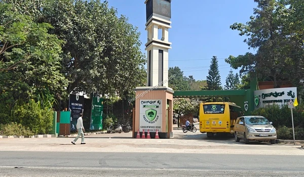 The main entrance gate and clock tower of Greenwood High International School near the Prestige Evergreen community