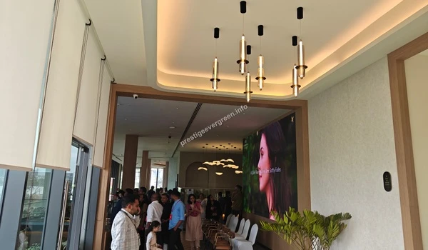 A wide view of the modern Prestige Evergreen site office lobby featuring a 1200 happy customers milestone display and festive decor