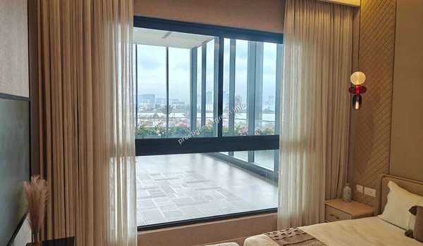 Interior view of the primary bedroom suite at Prestige Evergreen showcasing high-end upholstered wall panels, a designer bed frame, and floor-to-ceiling glass windows for maximum natural light