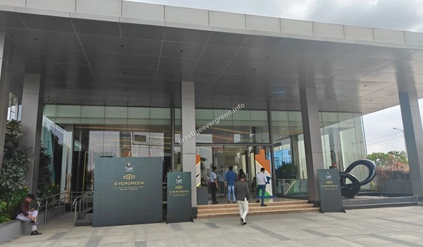 The elegant main entrance to the Prestige Evergreen office with sleek grey pillars, glass doors, and branded signage for visitors