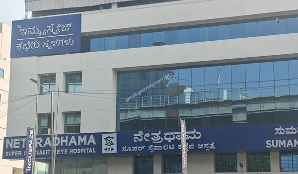 Exterior facade view of the Netradhama Super Speciality Eye Hospital building featuring large blue signage and glass windows at Prestige Evergreen