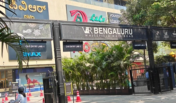 View of the bustling street outside Nexus Mall Whitefield, showing the active commercial neighborhood around Prestige Evergreen.