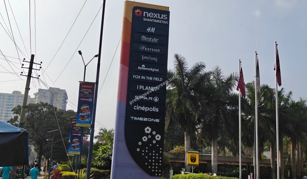 The towering brand totem pole at Nexus Shantiniketan displaying multiplex and retail options, highlighting the leisure hubs near Prestige Evergreen.