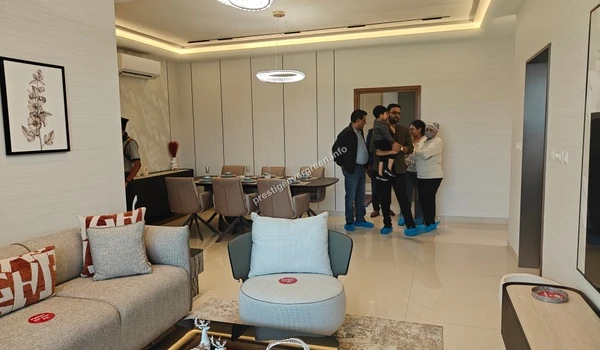 Wide view of the open concept living and dining area in a 3 BHK model unit at Prestige Evergreen highlighting the seamless floor plan