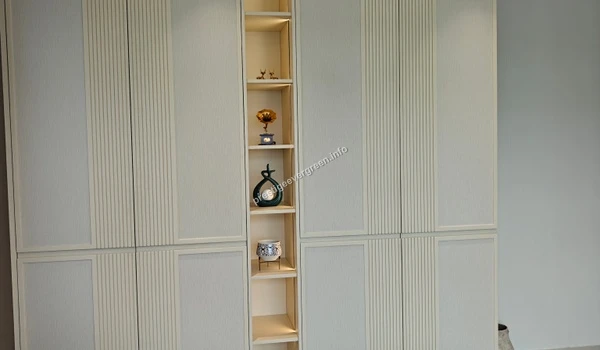 Close-up of premium white cabinetry at Prestige Evergreen featuring textured vertical slats and a warm-lit display niche for collectables