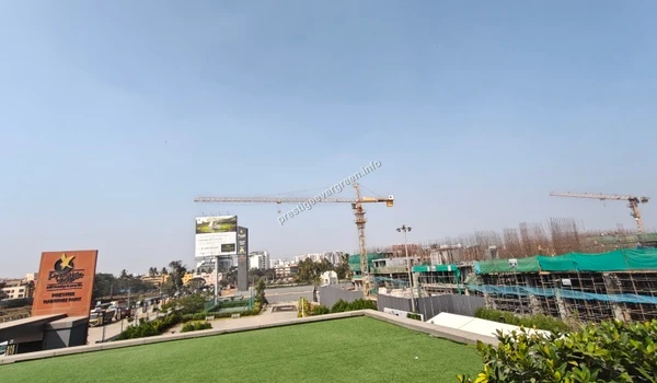 Comprehensive site view of Prestige Evergreen and Raintree Park featuring project signage and the vast construction landscape with tower cranes