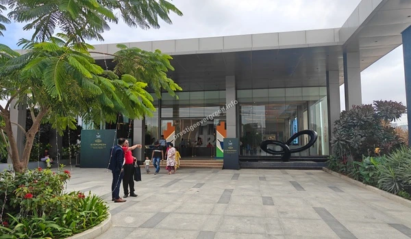 The grand entrance of the Prestige Evergreen site office featuring modern architecture and a clean outdoor plaza