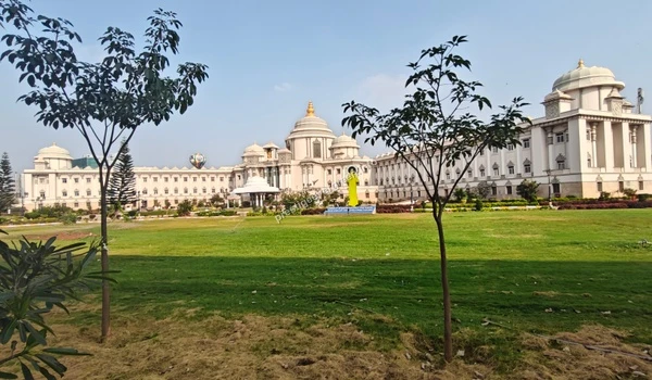 Majestic view of the Sri Sathya Sai Super Speciality Hospital featuring grand white domes and green lawns near Prestige Evergreen