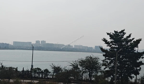 Impressive city view across Varthur Lake featuring high-rise developments and the shimmering water surface near the Prestige Evergreen site