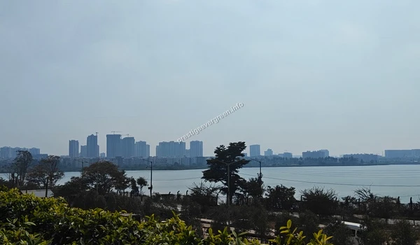 Stunning wide-angle perspective of the Varthur Lake waterfront near Prestige Evergreen capturing the peaceful blue waters and surrounding greenery