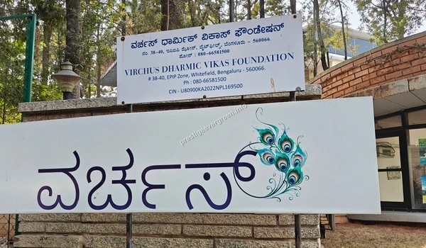 Signage board of Virchus Dharmic Vikas Foundation featuring a peacock feather design near Prestige Evergreen
