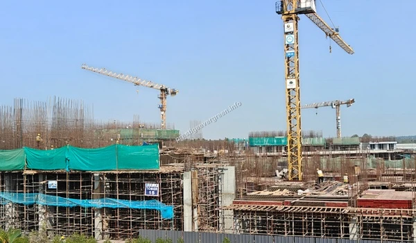 Ongoing construction progress at Prestige Evergreen featuring active tower cranes and structural development for the Raintree Park towers