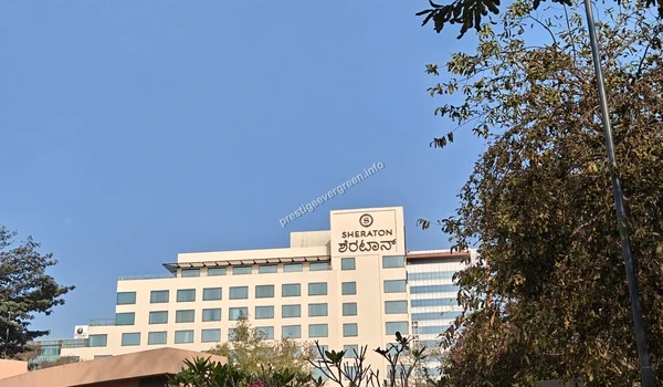 Top of the Sheraton hotel building displaying the brand logo against a blue sky near Prestige Evergreen